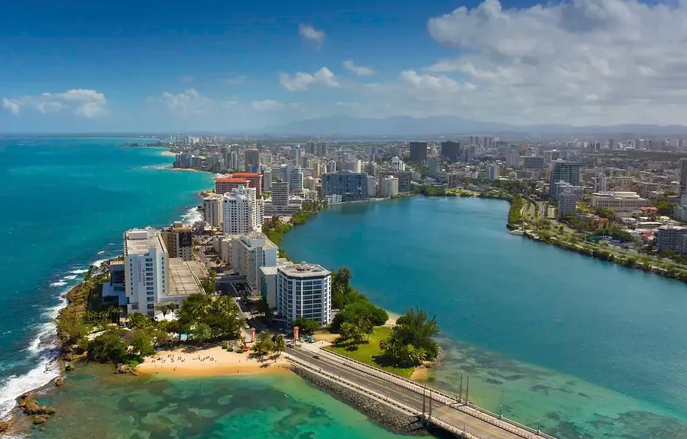 Aerial view of a coastal city in Puerto Rico with buildings and a beach