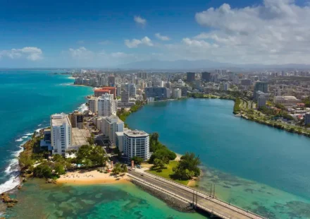 Aerial view of a coastal city in Puerto Rico with buildings and a beach