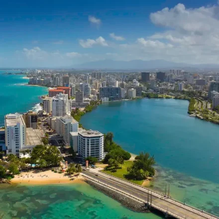 Aerial view of a coastal city in Puerto Rico with buildings and a beach